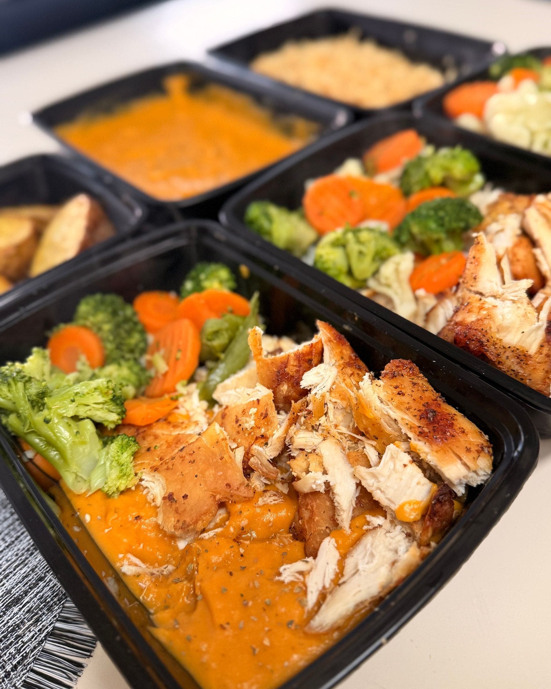 Trozos de pollo dorado sobre puré de camote, con brócoli, zanahoria y habichuelas verdes